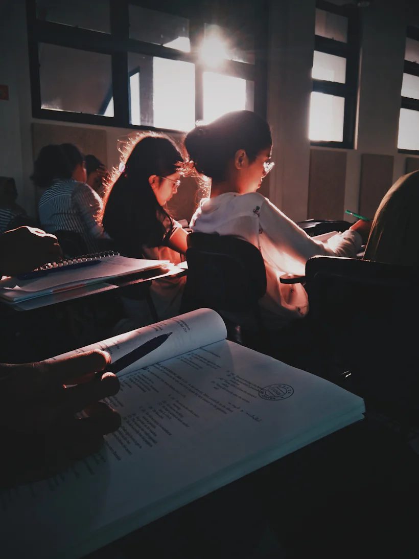 Students reading textbooks in a sunlit classroom