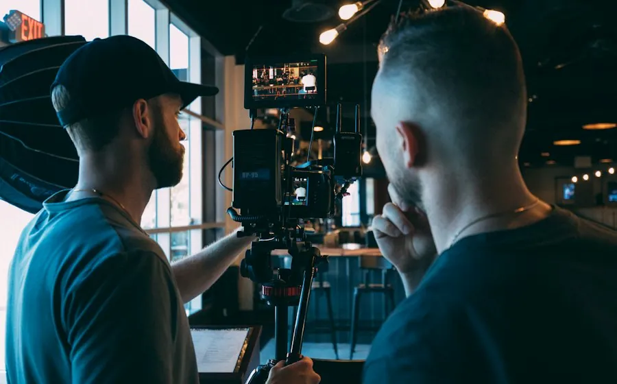 A videographer filming with a professional video camera